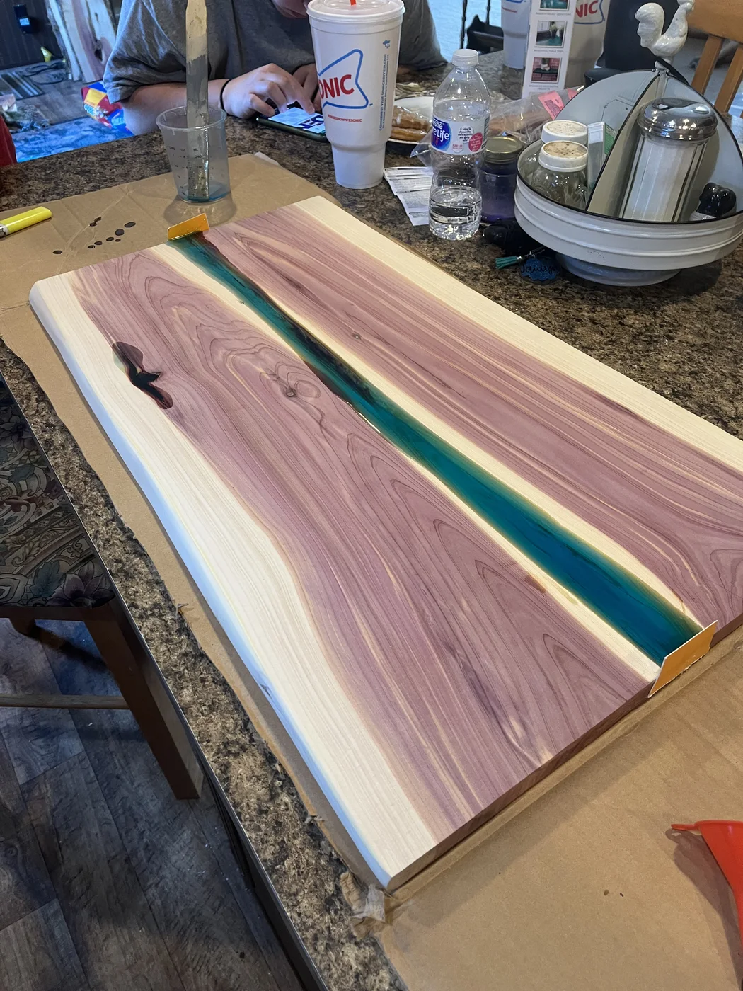 Wood tabletop with a blue-green resin channel through the center